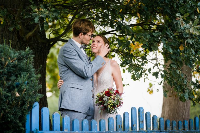 Hochzeitspaar in Schöppingen im eigenen Garten und blauem Holztor